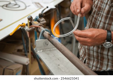 Close up of neon glass blower working with flame. Concept of handmade, high quality, artisan. Production of neon letters. gas burner. detail of craft and craftsmanship - Powered by Shutterstock