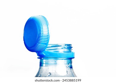 Close up of new cap attached to plastic bottle, connected to the neck of the bottle by solid tab attached to safety ring. They are intended to encourage recycling, as part of the fight against litter.