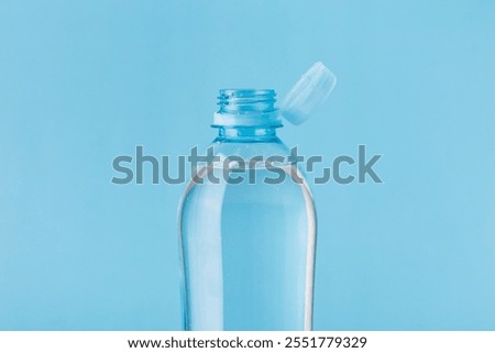 Close up of new cap attached to plastic bottle, connected to the neck of the bottle by solid tab attached to safety ring. They are intended to encourage recycling, as part of the fight against litter