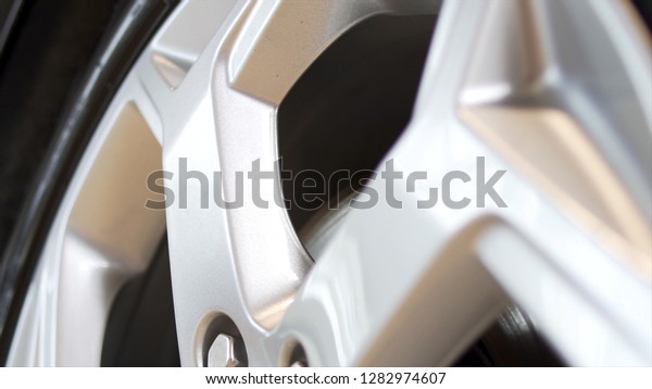 Close up of a new, silver car rim. Stock. New rim\
and car alloy wheel.