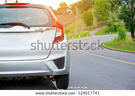 Close up of new silver hatchback car parking on local road
