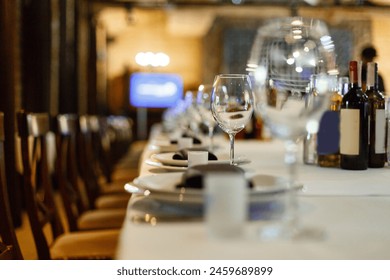 Close up new white porcelain tableware plates on purple place mats and empty wine glasses ready for dinner. Table settings wait for guests at home or restaurant. - Powered by Shutterstock