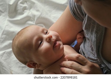 Close Up Of Newborn Baby Dreaming On Mothers Chest. Authentic Close Up Shot Of Small Baby In Mother's Hands. Candid Shot. Concept Of Children, Parenthood, Childhood, Life, Maternity, Motherhood.