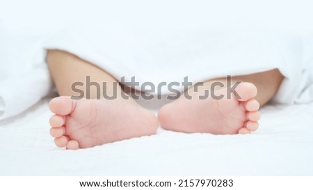 close up Newborn baby feet with White Blanket. tiny baby feet.
