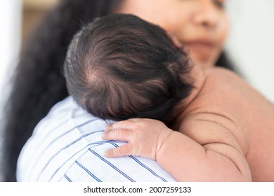 Close Up Of Newborn Baby Sleeping On Mother Shoulder. African American Mom Comforting Her Baby