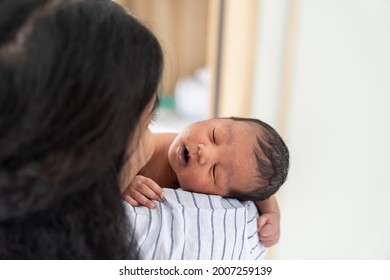 Close Up Of Newborn Baby Sleeping On Mother Shoulder. African American Mom Comforting Her Baby