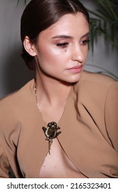 Close Up Non Retouched Image Of Brunette Model With A Big Mole On Her Face, Professional Make Up And Up-do Hairstyle. Unconventional Beauty Body Positivism. Brown Blazer Decorated With Pin Brooch