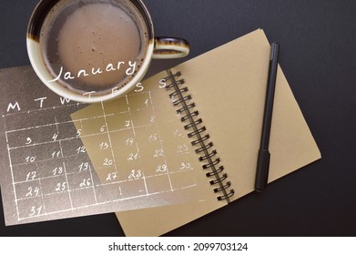 

Close up of  notebook, notepad and coffee mug on black background.new year 