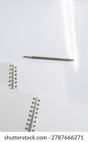 Close up notebook pages and spiral binding on white background in studio. Minimal stationery, elegant branding, creative productivity, modern workspace, clean composition.