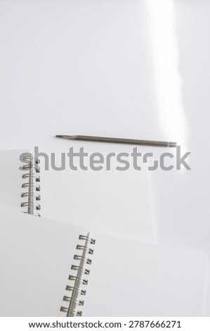 Close up notebook pages and spiral binding on white background in studio. Minimal stationery, elegant branding, creative productivity, modern workspace, clean composition.