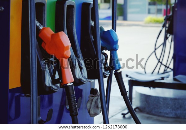 close up nozzle fuel for fill oil into car or\
motorcycle tank at pump gas station, transport energy,\
transportation power business technology concept\
