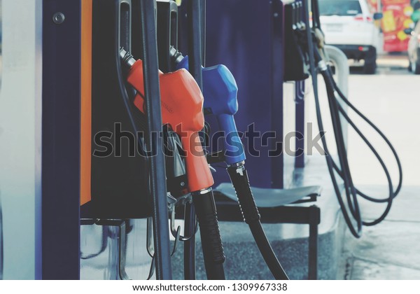 close up nozzle fuel for fill oil\
into car or motorcycle tank at pump gas station, transport energy,\
transportation power business technology concept, vintage\
tone