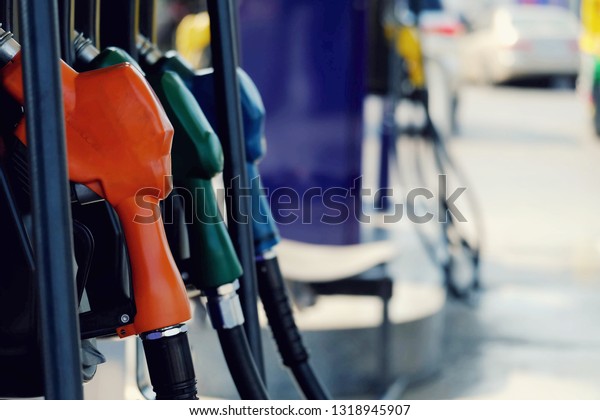 close up nozzle fuel for fill oil\
into car or motorcycle tank at pump gas station, transport enegry,\
transportation power business technology concept, vintage\
tone