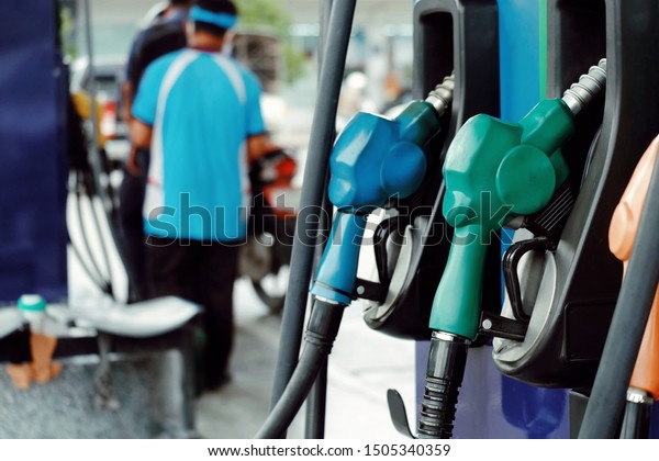 close up nozzle fuel for fill oil into\
car or motorcycle tank at pump gas station, transport energy\
service, transportation power business technology\
concept
