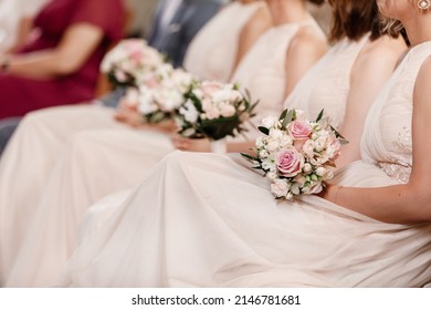 Close Up Of Nude Bridesmaids Dresses, Flower Bouquets, Modern And Trendy Gowns Sitting On Wedding Ceremony. Wedding Day. High Quality Photo.