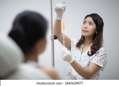 Close up of nurse or doctor preparing and adjusting infusion or chemotherapy drip for the patient in hospital or beauty salon. Healthcare and medicine concept