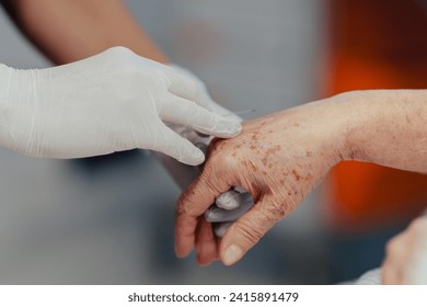 Close up of nurse insering IV cannula in vein, hand. Senior woman in intensive care unit in hospital. IV, intravenous therapy for elderly patient. - Powered by Shutterstock