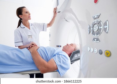 Close Up Of A Nurse Operating A CT Scan Machine While A Patient Is Laying On It