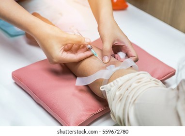 Close Up Nurse Pricking Needle Syringe In The Arm Patient Drawing Blood Sample For Blood Test