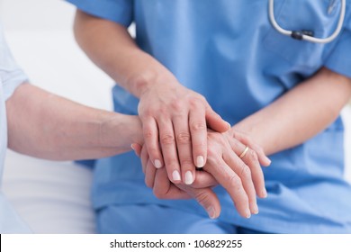 Close Up Of A Nurse Touching Hand Of A Patient In Hospital Ward