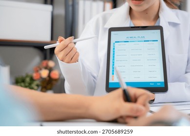 Close up nutritionist using tablet to explaining personalized meal plan with AI to patient during healthcare consultation, healthy lifestyle, woman dietitian showing nutrition plan with AI on tablet.