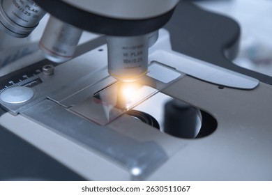 Close up objective lens microscope in laboratory. Examining histological sample, a biopsy in the laboratory of cancer research. Modern technology using a microscope