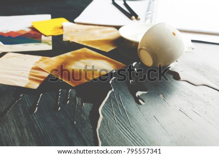 Close up of office desk with supplies and spilt coffee. Trouble and problem concept 

