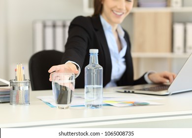 Close Up Of An Office Worker Hand Reaching A Glass Of Bottled Water