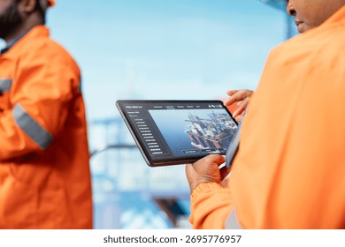Close up of offshore platform experts using tablet app to monitor equipment performance in real time. Drilling rig colleagues working together to calibrate gear with asset management system on device