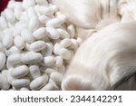 close up ofwhite silkworm cocoons with silk thread background.