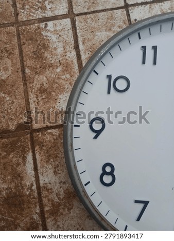 Close up of old analog clock face showing numbers seven to eleven, weathered rusty metal frame, cracked paint, dirty grunge tile floor background, vintage time concept, urban decay texture, retro background, copy space for text
