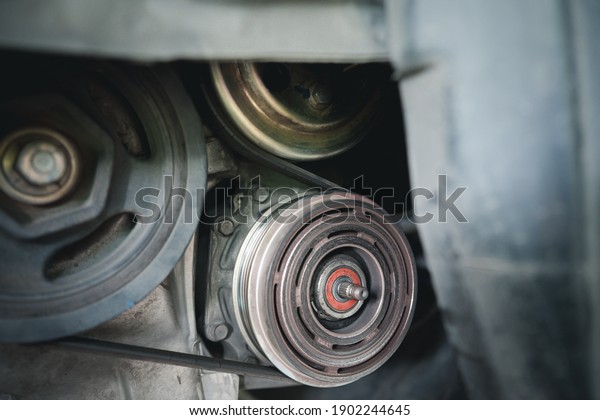 Close up old bearing of Air compressor clutch mistake\
on car engine and belt and pulley transmission in repair process of\
car