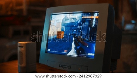 Close Up Of Old Desktop Computer With 3D First-Person Shooter Video Game In Retro Garage Late At Night In Nineties. Dated PC Of Gamer Running Popular Game With Character Playing Against Enemies.