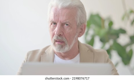 Close Up Of Old Man In Denial While Using Laptop In Office