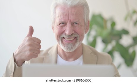 Close Up Of Old Man Doing Thumbs Up Using Laptop In Office