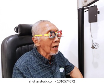 Close Up Of Old Man Using A Glasses Phoropter While Checking His Myopic Eyes At Ophthalmologist