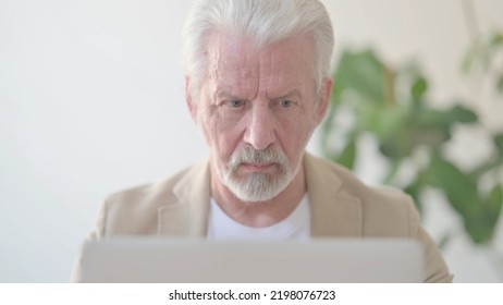 Close Up Of Old Man Using Laptop In Office