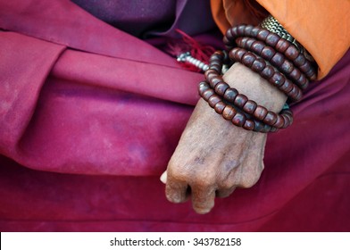 Close up old monk's hand with prayer beads. - Powered by Shutterstock