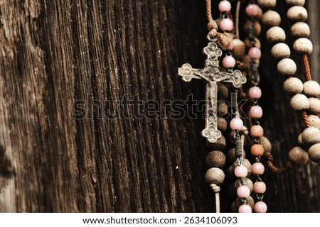 Close up old rosary against ancient wood doors background of church ruins. Close up horizontal image.