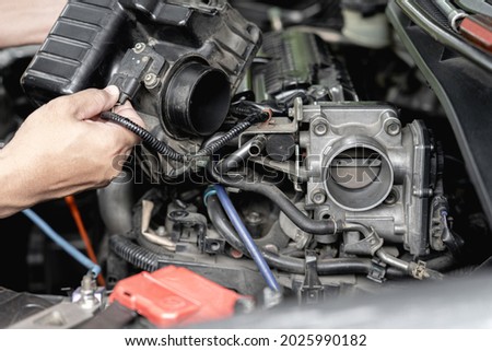 Close up old throttle Body of car in engine room with and a man hold air filler cover in car service engine throttle valve cleaning and maintenance : car service concept photo