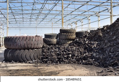 Close up of old used tires and shredded tire pile in background