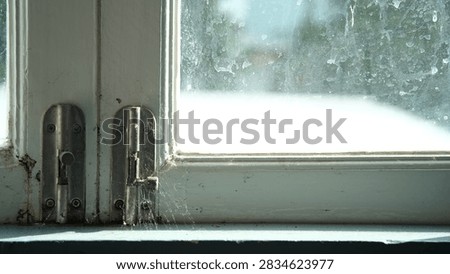 close up old window lock,lactch and a cobweb,white wood window,quiet vibe,lifeless,dirty window