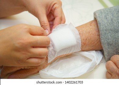 Close Up Old Woman Wrinkled Skin Hand, Upper Limb Or Arm To The Wounded Waiting For Nurse Treatment On Wound Dressing A Bloody And Brine Of Patient On White Background.