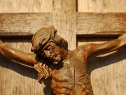 Close Up Of An Old Wooden Crucifix, Face Of Jesus Christ On Wooden Cross In Sunlight