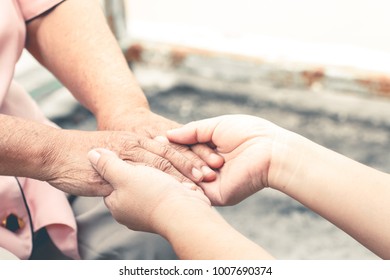 close up old and young hand of asian woman holding on light background - Shutterstock ID 1007690374