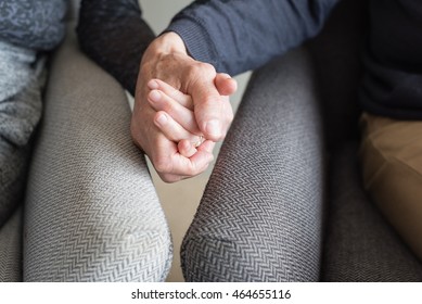 Close Up Of Older Couple In Armchairs Holding Hands (cropped And Selective Focus)