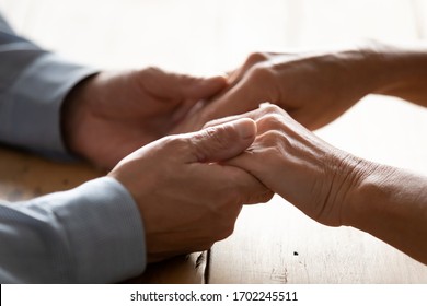 Close Up Older Husband Supporting Wife, Holding Hands On Wooden Table, Expressing Empathy And Understanding, Mature Man Comforting Woman, Helping With Problems, Trusted Relationship In Marriage