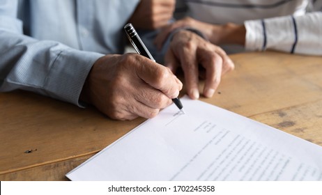 Close up older man putting signature on legal documents, mature couple, wife and husband making purchasing or investment deal, taking loan or buying new house, senior male signing contract