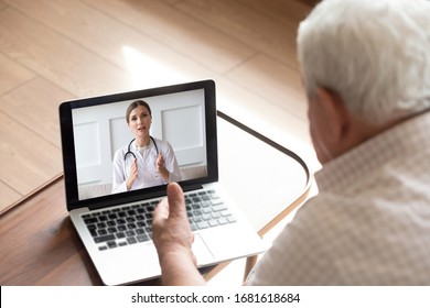 Close up older man talking with doctor by video call, using medical apps on laptop, service, friendly young woman wearing white uniform coat with stethoscope consulting mature senior patient online