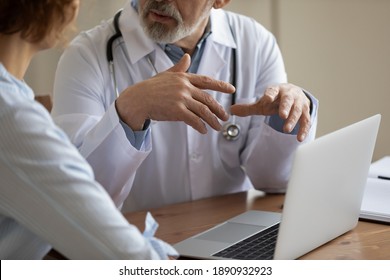 Close Up Older Mature Male Doctor Physician In White Uniform Gesturing, Explaining Medical Insurance Program Presentation On Computer To Focused Patient Or Giving Healthcare Advice At Appointment.